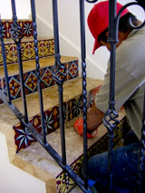 Santa Barbara artisan installing decorative sSpanish tile on staircase in Santa Barbara, California